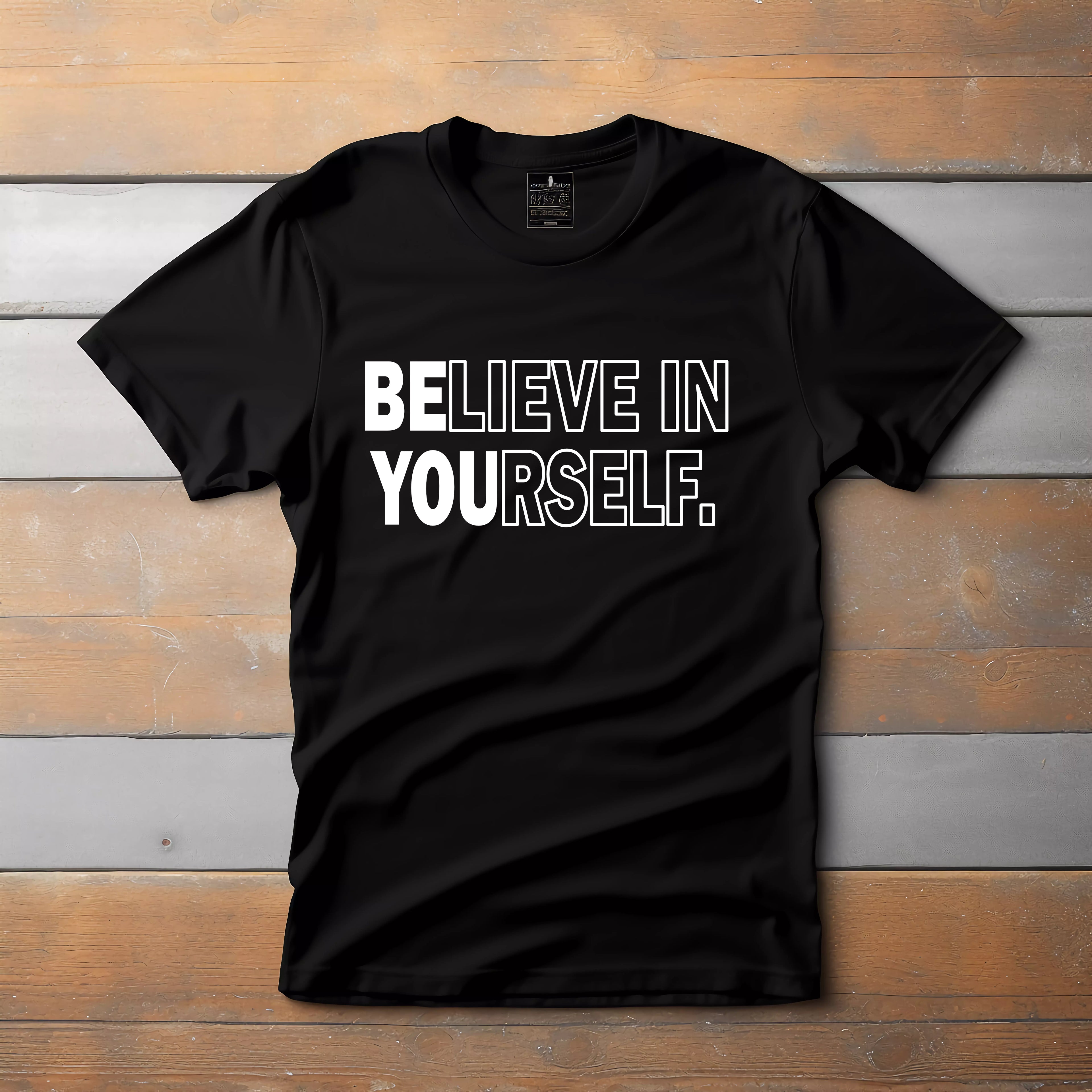 Black t-shirt with 'BELIEVE IN YOURSELF' text on a wooden background