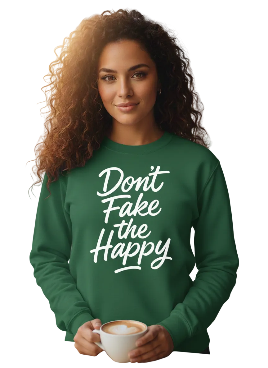 Woman wearing a green sweatshirt with 'Don't Fake the Happy' text, holding a coffee cup in a cafe.
