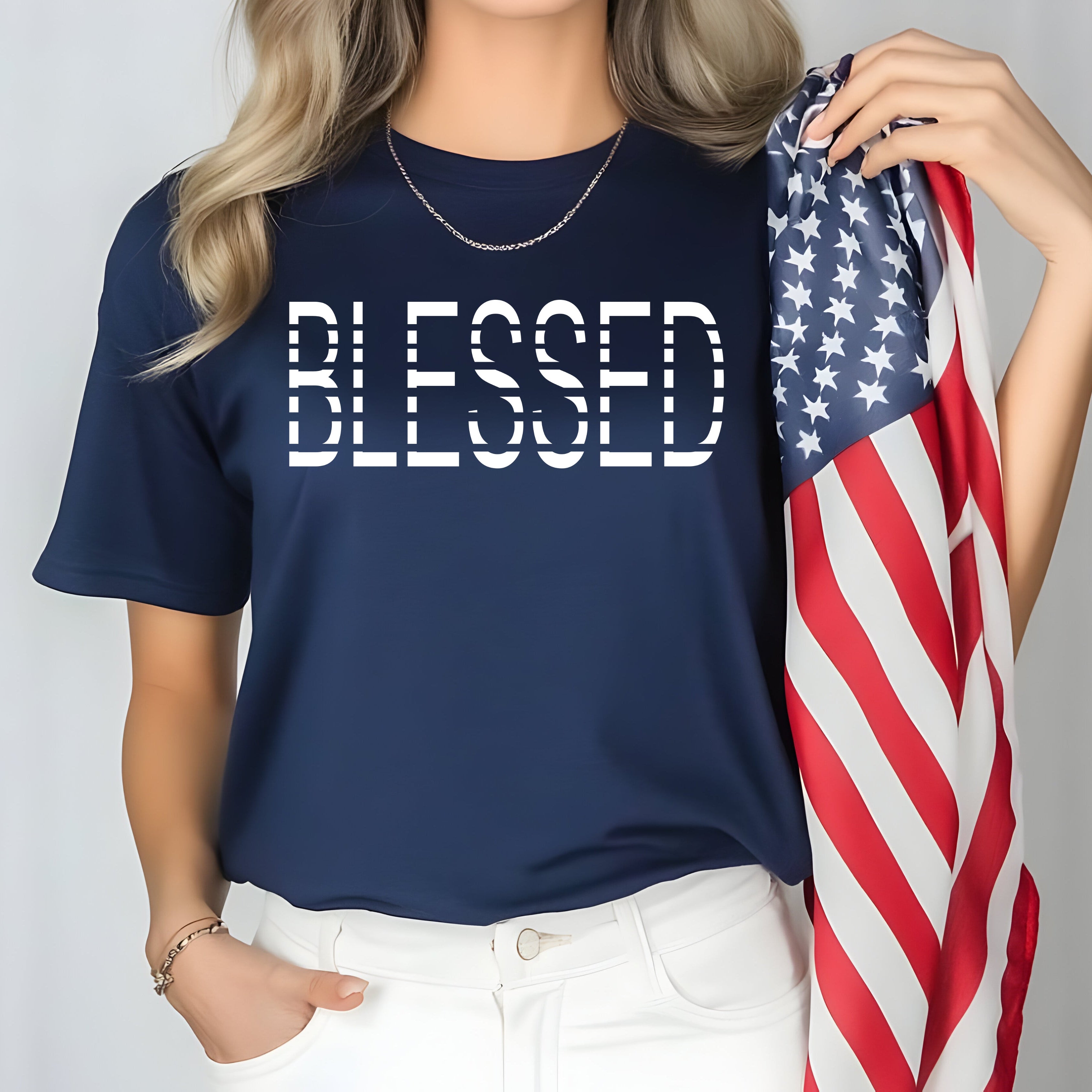 Person wearing a navy blue t-shirt with 'BLESSED' text, holding an American flag.